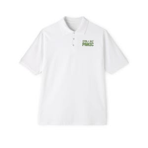 May include: White polo shirt with short sleeves and a button-down collar. The shirt features the text "CTRL+ALT PANIC" in green on the chest. A casual, everyday top.