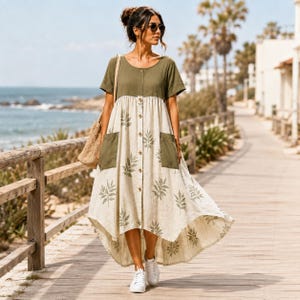 May include: A midi-length dress featuring a solid olive green bodice and a cream-colored skirt with a repeating green leaf pattern. The dress has short sleeves, a button-down front, two large patch pockets, and a high-low hemline with white sneakers.