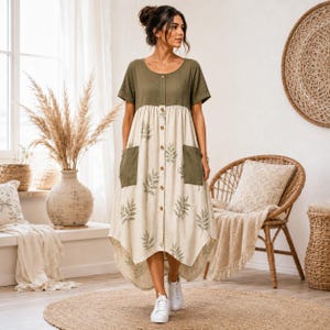 May include: A midi-length dress featuring an olive green bodice and a cream-colored skirt with a green leaf print. The dress has short sleeves, a round neckline, a front button placket, and two olive green patch pockets on the front skirt.