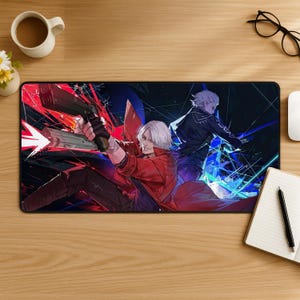 May include: A rectangular desk mat featuring a vibrant anime-style illustration of two characters with white hair. One character in a red coat holds a handgun with a muzzle flash, while the other in a dark coat stands behind amidst blue light effects.