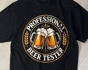 May include: A black short-sleeve t-shirt featuring a circular graphic on the chest. The design displays two clinking beer mugs filled with golden liquid and white foam, surrounded by the text PROFESSIONAL BEER TESTER in a bold font.