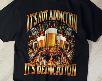 May include: A black short-sleeve t-shirt featuring a graphic of beer mugs and a grill surrounded by flames. The text reads IT'S NOT ADDICTION IT'S DEDICATION. The design includes golden yellow and orange hues, depicting beer, grilling tools, and fire.