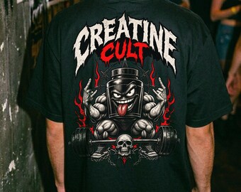 May include: A black t-shirt featuring a graphic on the back with the text CREATINE CULT in white and red. The design shows a muscular anthropomorphic supplement container with a face, tongue out, and hands making rock signs, lifting a barbell.