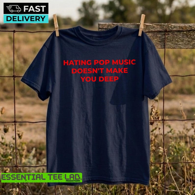 May include: A navy blue short-sleeved t-shirt featuring the red text "HATING POP MUSIC DOESN'T MAKE YOU DEEP" printed in a simple sans-serif font across the center of the chest. The garment has a crew neckline and a standard fit.
