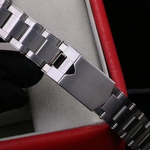 Pu&ograve; includere: Un cinturino per orologio in acciaio inossidabile color argento con finitura spazzolata e chiusura pieghevole. La chiusura &egrave; incisa con il marchio TUDOR e presenta un intaglio a forma di scudo. Le maglie sono rettangolari con bordi lucidi.