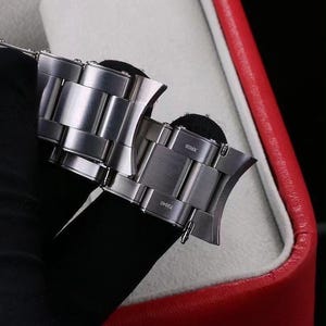 Pu&ograve; includere: Un cinturino per orologio in acciaio inossidabile color argento con finali curvi. Le maglie in metallo hanno una finitura spazzolata. Il testo XR05 e 72040 &egrave; inciso sulla superficie dei finali, che includono anche piccole barrette a molla.