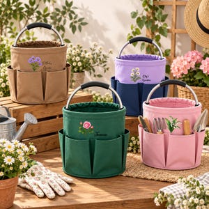 Puede incluir: Cuatro bolsas cilíndricas de lona para herramientas de jardín con asas de metal y bolsillos exteriores. Las bolsas son de color beige, morado, verde oscuro y rosa. La bolsa beige tiene flores moradas y texto, la morada flores blancas y la verde una rosa.