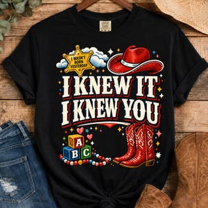 Puede incluir: Una camiseta negra de manga corta con un estampado gr&aacute;fico que incluye una estrella de sheriff amarilla con la inscripci&oacute;n I WASN'T BORN YESTERDAY, un sombrero de vaquero rojo, botas de vaquero rojas y bloques de letras. El texto dice I KNEW IT I KNEW YOU.