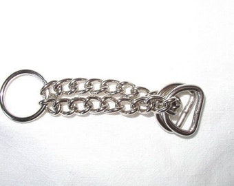 Peut inclure: Une chaîne en argent avec un anneau à une extrémité et une double boucle à l'autre extrémité.