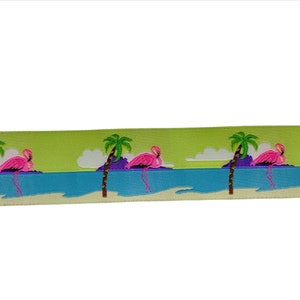 Könnte beinhalten: Grünes Band mit einem sich wiederholenden Muster aus rosafarbenen Flamingos, die auf einem Strand mit Palmen stehen. Der Hintergrund ist ein hellblaues Meer.