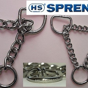 Op de afbeelding: Twee zilveren hondenhalsbanden met een driehoekige vorm. De halsband aan de linkerkant is 25 mm breed en de halsband aan de rechterkant is 20 mm breed. Beide halsbanden hebben aan elk uiteinde een D-ring en een ronde ring in het midden.