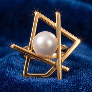 May include: A gold-toned ring featuring an abstract geometric frame composed of intersecting straight bars. A single, smooth, round white pearl is set centrally within the open structure of the metal design, creating a balanced and structured appearance.