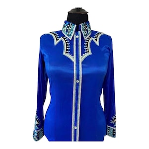 May include: A long-sleeved royal blue button-down shirt featuring a structured collar and front placket adorned with intricate white, black, and light blue geometric patterns and clear crystal embellishments along the seams and cuffs.