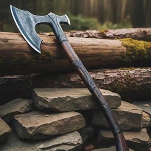 May include: A battle axe featuring a dark metal head with intricate floral engravings and a sharp, curved blade. The handle is crafted from dark wood, accented with ornate metal fittings that match the head, providing a balanced appearance.