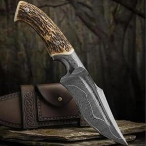 Puede incluir: Un cuchillo de hoja fija con un mango de asta marrón texturizado asegurado con dos pasadores de metal y una hoja de acero afilada y puntiaguda con un patrón de Damasco ondulado. El cuchillo incluye una funda de cuero marrón con nudos.