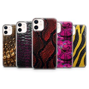 Op de afbeelding: Vijf smartphonehoesjes op een rij, elk met een eigen textuur geïnspireerd op dieren. De ontwerpen omvatten metallic gouden krokodillenhuid, donkerpaarse schubben, donkerrode slangenleer, levendige roze slangenpatronen en gele en zwarte strepen.