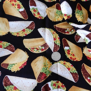May include: Black fabric with a repeating pattern of yellow and brown tacos. The tacos have lettuce, cheese, and meat fillings.
