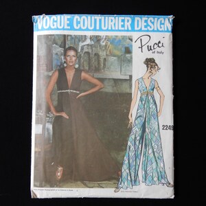 May include: Vintage Vogue Couturier Design sewing pattern featuring a Pucci of Italy design. The pattern cover shows a woman in a long, dark dress and a drawing of a blue and white patterned jumpsuit. The text "Vogue Couturier Design" is at the top.