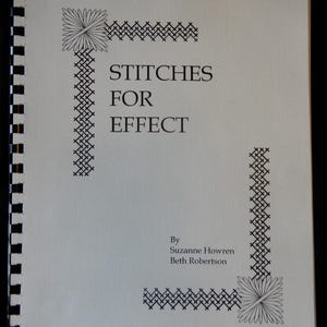 May include: A white ceramic mug with a black handle and the text "But First, Coffee" in a black, handwritten-style font. The mug is on a white surface.