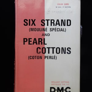 May include: A vintage DMC color card for six strand and pearl cottons. The cover is divided into two vertical sections, one pink and one white, with black text. The text includes "SIX STRAND (MOULINÉ SPÉCIAL) AND PEARL COTTONS (COTON PERLÉ)".