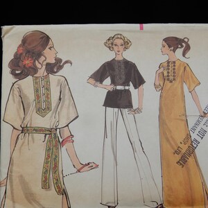 May include: Vintage sewing pattern featuring three women's fashion designs. The illustrations depict a tunic dress, a black top with white pants, and a long yellow dress. The designs showcase embroidered details and a belted waist, reflecting a retro style.