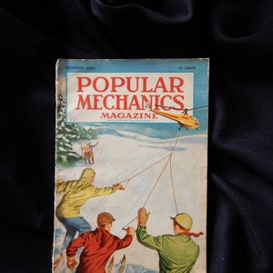 May include: Vintage December 1950 issue of Popular Mechanics magazine. The cover features a winter scene with skiers and a helicopter. The magazine's title is in large red letters, with the price of 35 cents in the upper right corner.