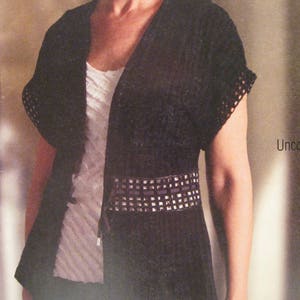 May include: A black short-sleeved cardigan with a V-neck and a silver studded belt. The cardigan is made of a lightweight fabric and has a relaxed fit.
