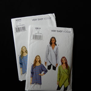 May include: Two white Very Easy Vogue sewing pattern envelopes against a black background. The patterns are for tops, with illustrations of the finished garments. One envelope is labeled V9111, size Y (Xsm-Sml-Med). The other is V9111, size ZZ (Lrg-Xlg-XXL).