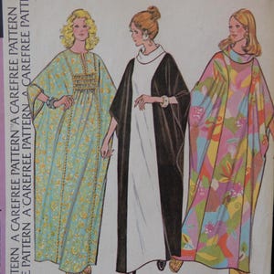 May include: A sewing pattern featuring three different styles of caftans. The first caftan is a light blue and green floral print, the second is a black and white caftan, and the third is a multi-colored caftan with a floral print. The pattern is labeled A, B, and C.