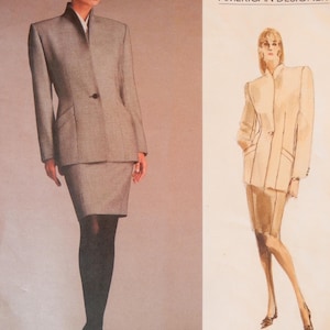 May include: A woman wearing a gray skirt suit with a single-button jacket and a white collared shirt. The image is from a Vogue Patterns advertisement, featuring an American Designer. The text "Vogue Patterns" and "American Designer" are visible.