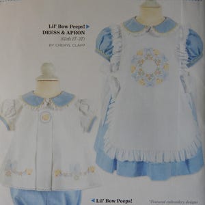 May include: A sewing pattern for a Lil' Bow Peeps dress and apron, and a diaper set. The dress and apron are white with blue accents and a floral embroidery. The diaper set includes a white top and blue bloomers. The text reads "FOR EVERYDAY & SPECIAL OCCASIONS".