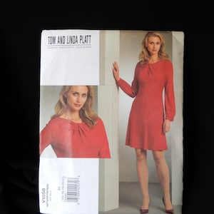 May include: A sewing pattern for a dress by Tom and Linda Platt, Vogue American Designer. The pattern is for sizes 14-16-18-20-22. The pattern shows a red dress with a knotted neckline and long sleeves.