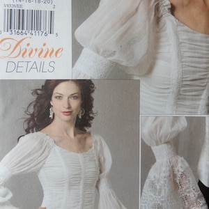 May include: A sewing pattern envelope labeled V8326 Divine Details featuring a white long-sleeved top with a square neckline, ruched bodice, and flared lace cuffs. The pattern is sized EE for 14-16-18-20 and includes a barcode and text.