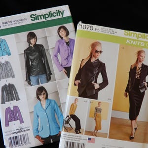 May include: Two Simplicity sewing pattern packages. The first package is for sizes 16-24 and features a black leather jacket, a purple jacket, and a light blue jacket. The second package is for sizes 12-20 and features a black leather jacket, a black and white knit top, and a black skirt.