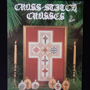 May include: Cross-stitch pattern booklet featuring a framed cross-stitch design of various crosses. The booklet includes instructions for creating seven different cross-stitch designs, including a large cross and six smaller ornaments.
