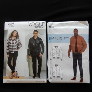 May include: Two sewing pattern packets. The Vogue Patterns packet, V1877, features a woman in a plaid jacket and a man in a leather jacket. The Simplicity packet, 59190, shows a man in a bomber jacket. Both packets have jacket illustrations.