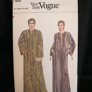 May include: A vintage Vogue sewing pattern featuring illustrations of two long, flowing garments. The pattern cover includes the text "Very Easy Vogue" and "All Sizes Included". One garment has a chevron pattern, the other is solid with tassel accents.