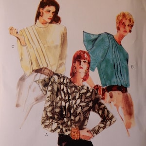 May include: Vogue Patterns sewing pattern featuring three women's fashion designs. The pattern includes size options and cutting layouts. The cover art showcases illustrations of the garments, including a top with a draped neckline and a patterned blouse.