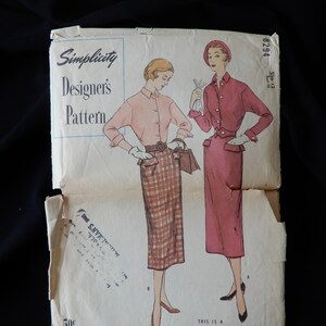 May include: Vintage Simplicity sewing pattern for a dress, size 12, with a plaid skirt and a solid top. The pattern is printed on paper and has a price tag of 50 cents.