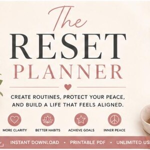 May include: A spiral-bound planner with a dusty pink cover titled The Reset Planner in black and pink text. The planner is displayed with open pages showing a My Dream Life section, a Monthly Reset Checklist, and a Vision Board page.