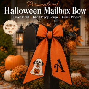 May include: An orange fabric mailbox bow with black scalloped edges. One tail features a graphic of a puppy dressed as a ghost holding a jack-o'-lantern, while the other tail displays a large black letter A. The bow is attached to a black mailbox.