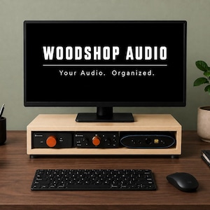 May include: A light-colored wooden monitor stand with a rectangular shelf holding three audio devices with orange knobs. The monitor above displays the white text WOODSHOP AUDIO and the tagline Your Audio. Organized. on a black background.