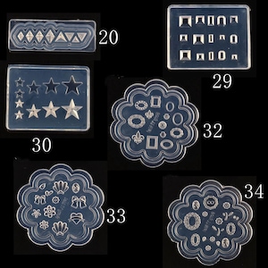 Puede incluir: Un conjunto de diez moldes de silicona transparentes para manualidades. Los moldes presentan diversas formas, incluyendo estrellas, diamantes, corazones y flores. Los moldes están numerados del 20 al 34.