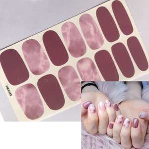 May include: Nail polish stickers with a pink and white marble design. The stickers are on a white sheet with the text "YMX485".