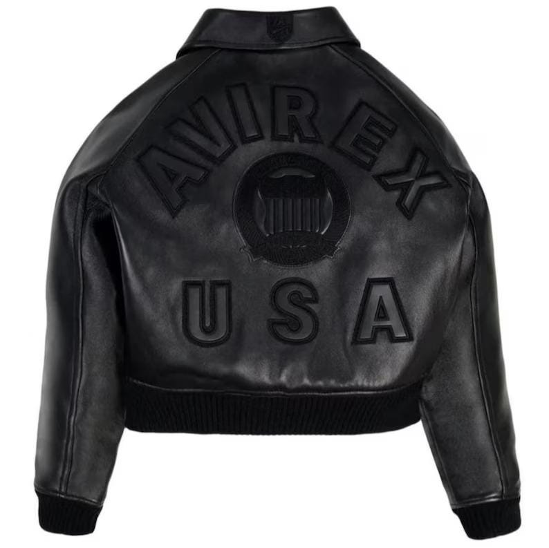 Op de afbeelding: Zwarte leren jas met de tekst "AVIREX USA" op de rug. De jas heeft een geribbelde zoom en manchetten, een kraag en een logopatch. De jas is een klassieke bomberstijl.