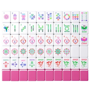 May include: A complete Mahjong set with white tiles featuring various symbols, numbers, and Chinese characters in red, green, and blue. The set includes pink tile holders. The tiles display hearts, flowers, and directional symbols.