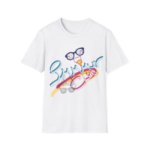 May include: White t-shirt with a colourful graphic design. The design features the word "Summer" in a playful, cursive font, along with sunglasses, a popsicle, and a bikini. The graphic is in shades of blue, yellow, pink, and purple.