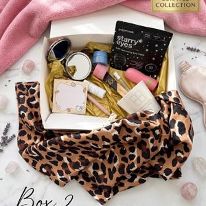 Peut inclure: Une boîte cadeau blanche contenant un masque pour les yeux auto-chauffant noir pdpmask starry eyes, un miroir de poche rond, un petit pot bleu, un tube rose, un tube blanc, un stylo, un bloc-notes illustré et un tissu à motif léopard.