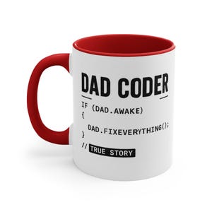 Op de afbeelding: Een witte keramische mok met een rode binnenkant en handvat. De voorzijde bevat zwarte tekst met DAD CODER gevolgd door een codefragment: IF (DAD.AWAKE) { DAD.FIXEVERYTHING(); } // TRUE STORY. Het ontwerp is op de buitenkant gedrukt.