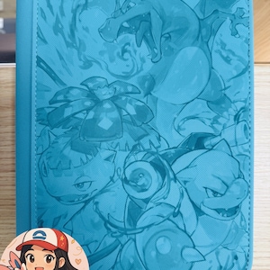 May include: A bright blue rectangular binder featuring a monochromatic embossed design of Charizard, Venusaur, and Blastoise. A circular sticker in the bottom left corner depicts an illustrated character wearing a red and white cap holding a Sylveon.